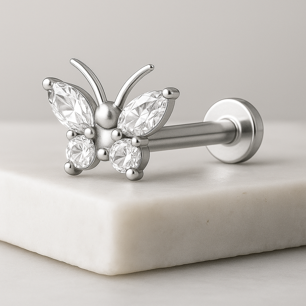 Butterfly-shaped earring with clear gemstones on a light background