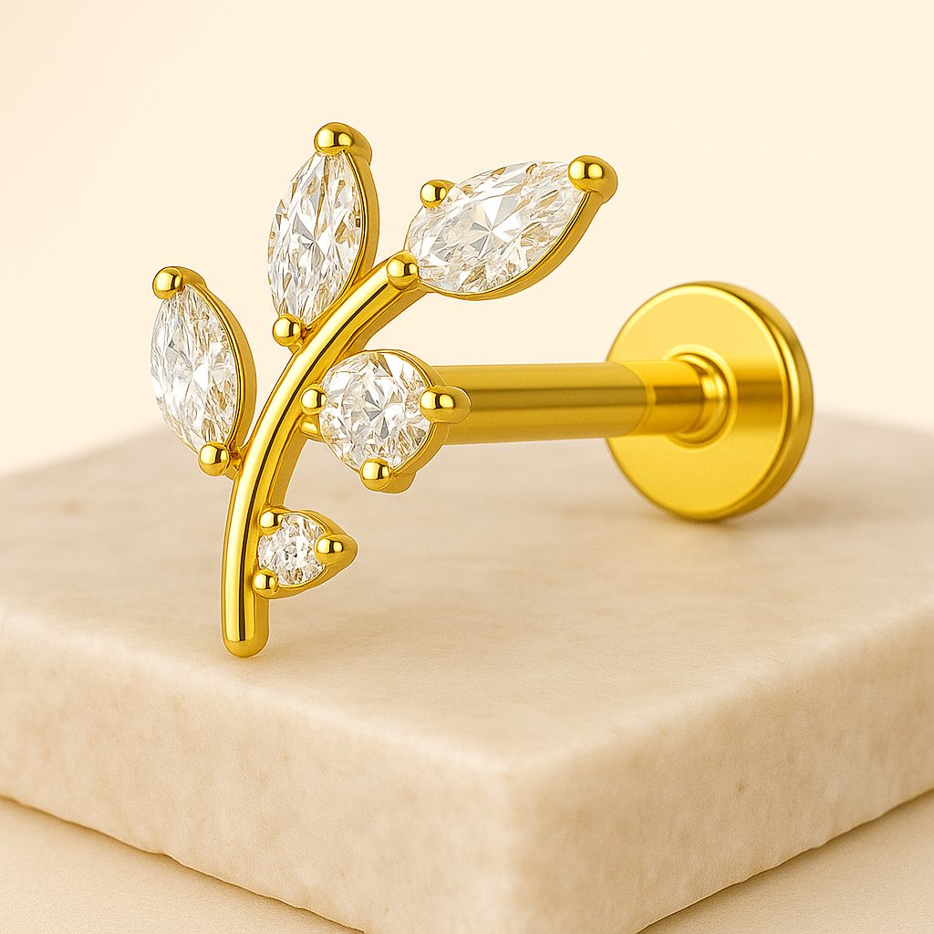 Gold earring with diamond-like stones on a beige background