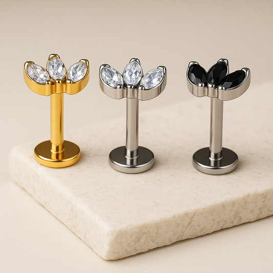 Three metallic Studs with tristone tops on a marble surface