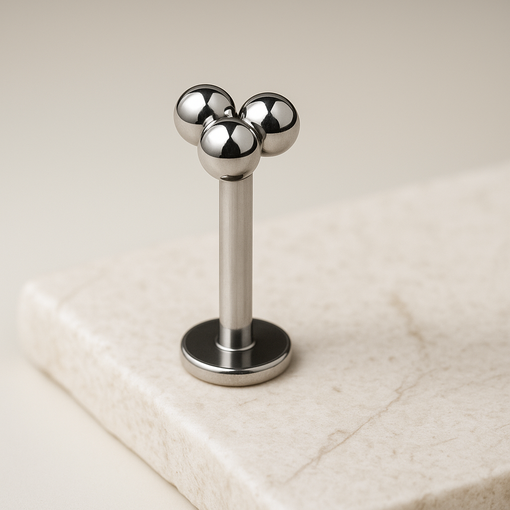 Metallic three-ball design on a beige background