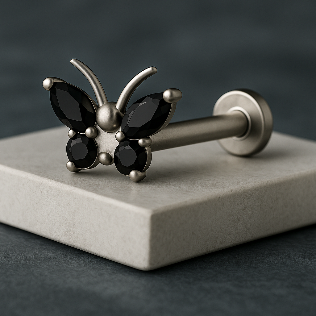 Butterfly-shaped barbell with black gemstones on a gray platform