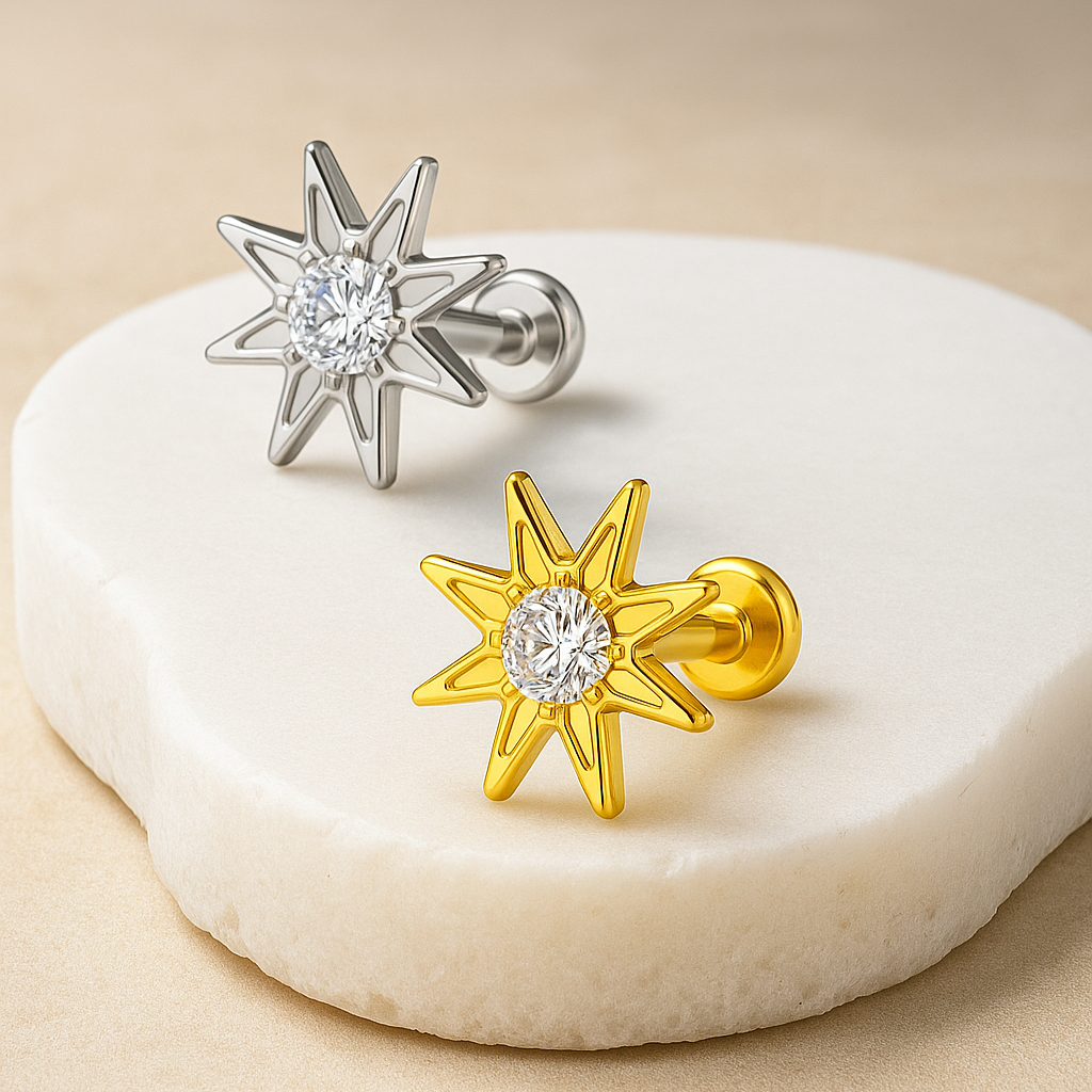 Star-shaped earrings in gold and silver on a white stone