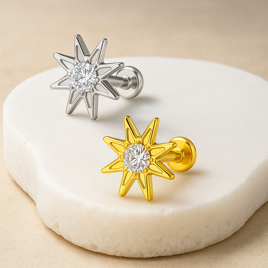 Star-shaped earrings in gold and silver on a white stone