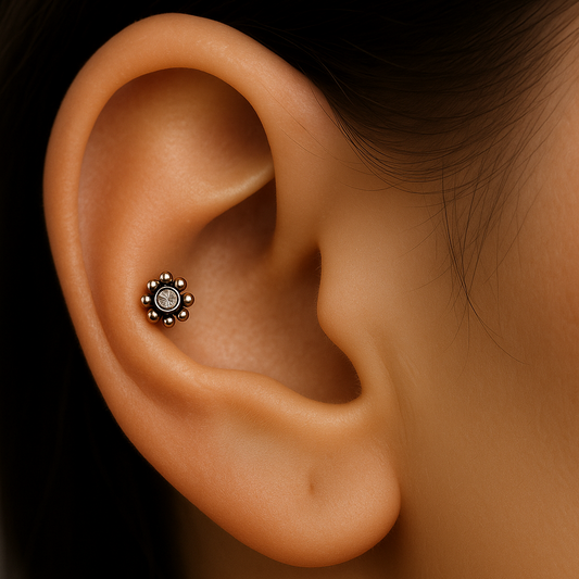 Close-up of an ear with a small earring on a dark background