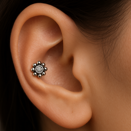 Close-up of an ear with a floral earring on a blurred background
