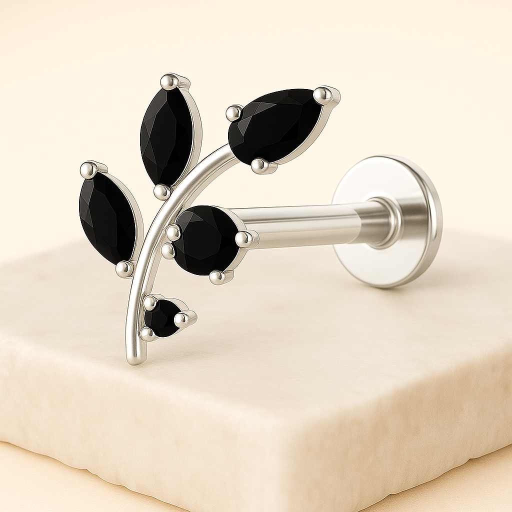 Silver labret with black gemstones on a beige background