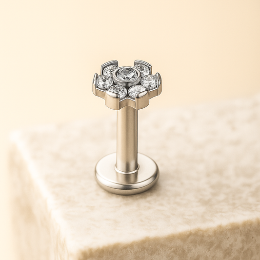 silver flower earring with gemstones on a beige stone background