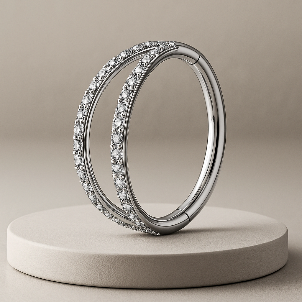 Silver cartilage ring with embedded diamonds on a beige platform