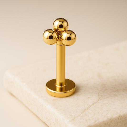 Gold cluster earring on a beige background