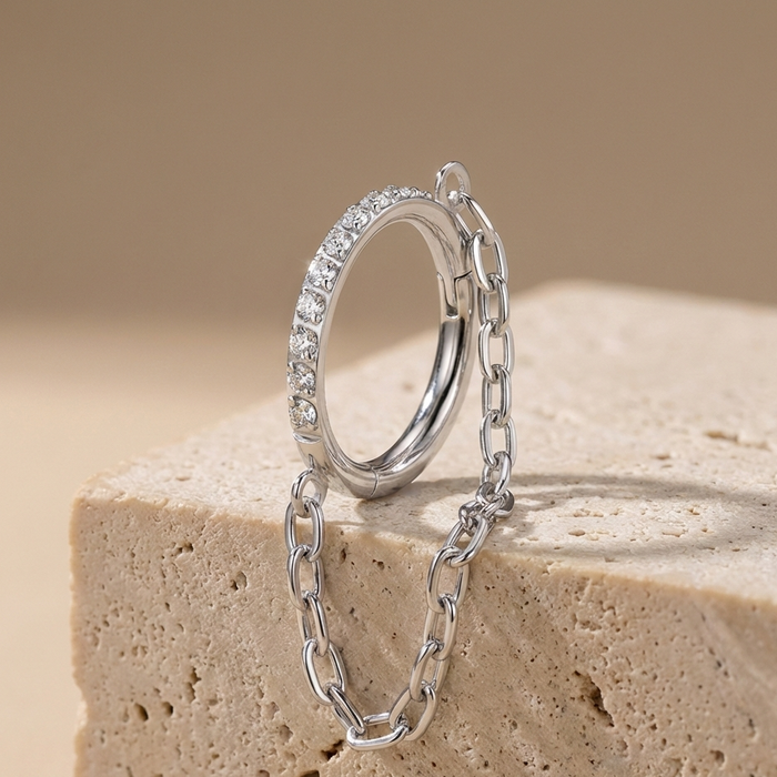 Zahara - Titanium Segment ring with side facing stones and chain – hypoallergenic piercing jewellery by Cura